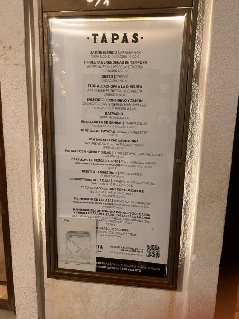 Tapas menu displayed on a board outside a restaurant wall